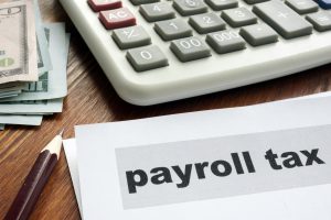 Payroll tax concept. Papers, calculator and money.